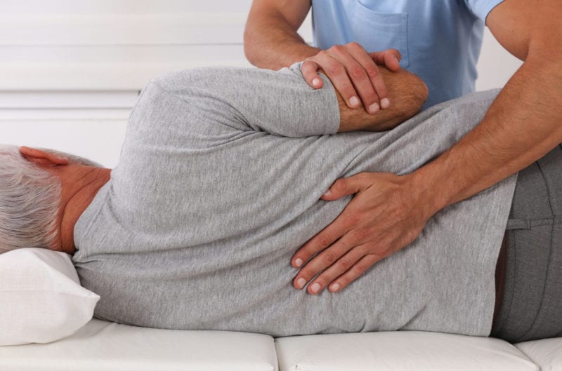 Chiropractic treatment, Back pain relief. Physiotherapy for senior male patient, Kinesiology